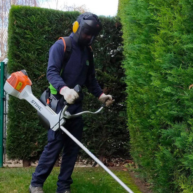 Paisajismo La Rioja cuida el equipamiento y seguridad de sus empleados. Empleado de Paisajismo La Rioja trabajando con una cortadora de hilo.
