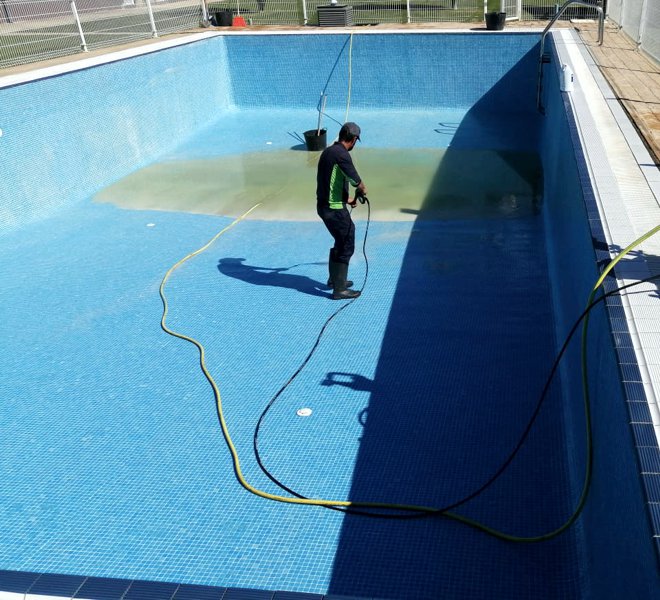 Paisajismo La Rioja - Limpieza profesional de vasos de piscina. Operario de Paisajismo La Rioja limpiando el vaso de una piscina.