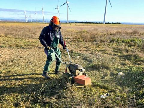 Operario de Paisajismo La Rioja con máquina desbrozadora trabajando en un parque eólico