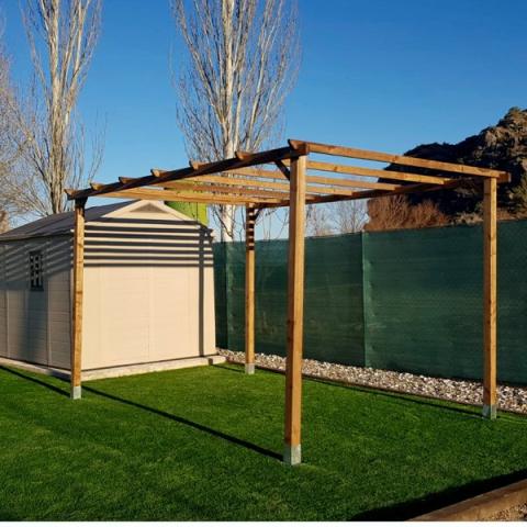 Jardín con pérgola de madera y césped artificial.